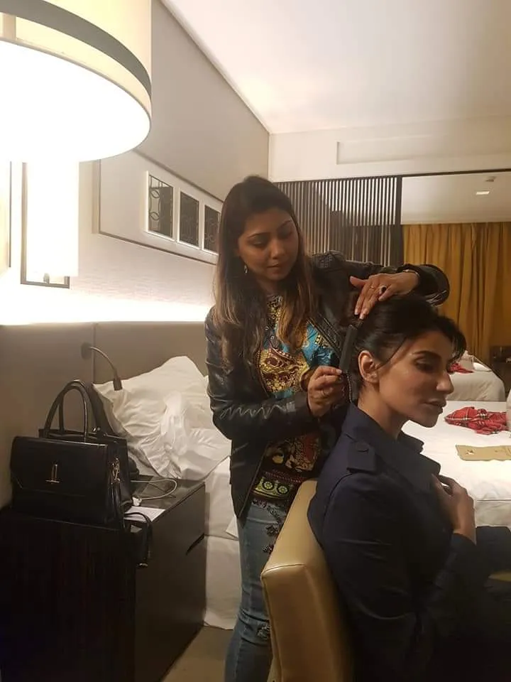Woman styling another woman's hair in a hotel room
