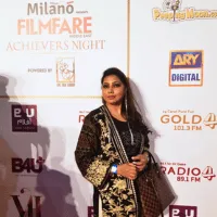Barna in a gold patterned jacket at an event