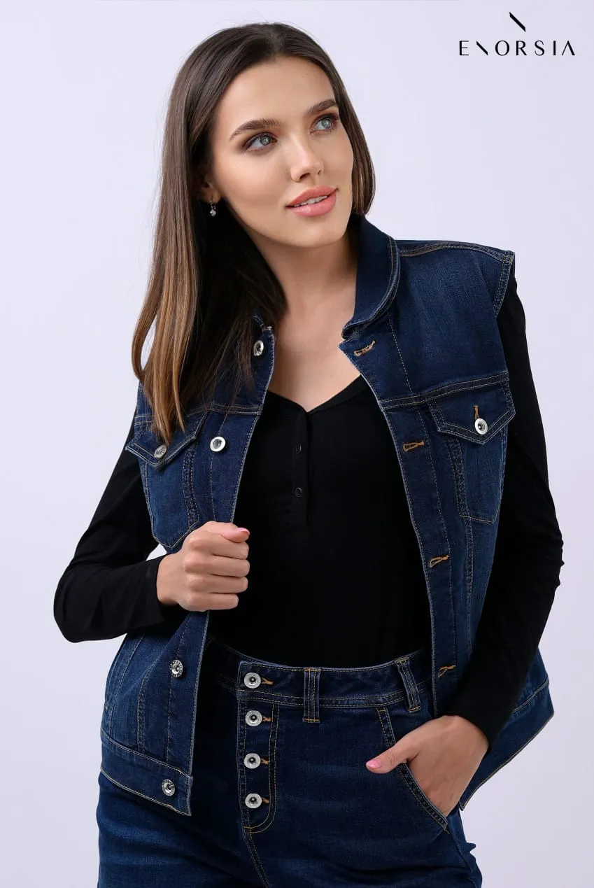 Model in a denim waistcoat and black top posing in front of a brand backdrop at a commercial shoot